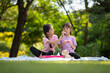 Cute little Asian children eating sweet donuts, tasty food for kids, Funny time in the park