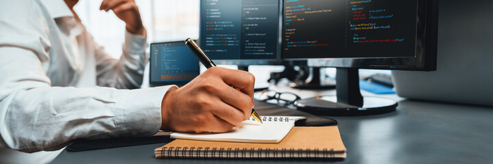 Wall Mural - software engineer working on application development on his computer display code and script on moni