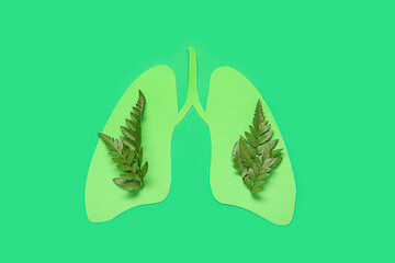 Paper lungs with leaves on green background. Lung cancer concept