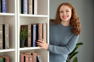 Canvas Print - Young woman beside bookshelf in library