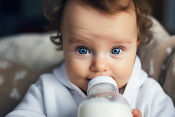 Wall Mural - baby boy drinking milk from his baby bottle