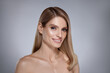 © New Africa - Portrait of attractive woman with blonde hair smiling on grey background