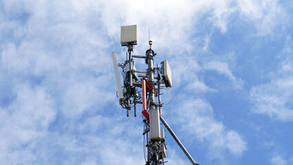 Wall Mural - Telecommunication tower of 4G and 5G cellular. Macro Base Station. 5G radio network telecommunication equipment with radio modules and smart antennas mounted on a metal against cloulds sky background.