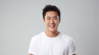© Phoophinyo - Asian man happy and happy, portrait of asian man with wow face, happy man, looks back at the camera, man wearing white t - shirt is delighted with light gray background.