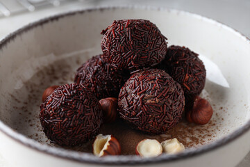 Wall Mural - Brigadeiro and hazelnuts in white bowl, close up