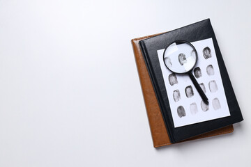 Wall Mural - Books, magnifying glass with fingerprints on a white background