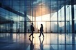 © Pacharee - Business people walking in glass office building.