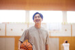 体育館でバスケットボールの練習をする日本人高校生の男性