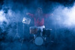© serikbaib - male drummer plays drums on a black background