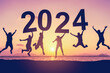 Leinwandbild Motiv Silhouette friends jumping and holding number 2024 on sunset sky abstract background at tropical beach. Happy new year and holiday celebration concept.