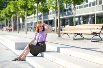 Wall Mural - Beautiful successful middle aged woman posing on the street photo shoot