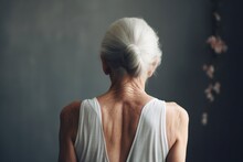 rear view of senior woman. Senior grey-haired woman standing backwards looking away. Rear view senior woman showing back