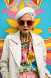 © malgo_walko - Close up of an old, eccentric white woman dressed in colorful shirt, hat  and red sunglasses. She wears haute couture fashion, colorful background. Summer, colorful vibes concept.