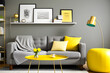 © Nyetock - Modern room interior concept, gray bookshelf, gold lamp and frame close up, green metal chair with stylish pillows and blanket, brown and yellow decorative walls.