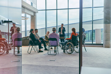 A diverse group of young business entrepreneurs gathered in a circle for a meeting, discussing corporate challenges and innovative solutions within the modern confines of a large corporation