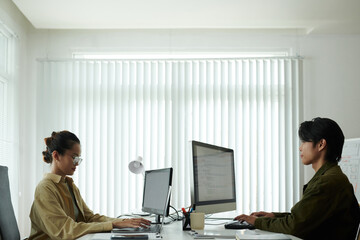 Software developers working on computers in modern office of it company
