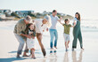 © Wesley/peopleimages.com - Grandparents, children and big family with play at beach, comic laugh or bonding for love, sunshine or excited on vacation. Mom, dad and kids by sea, waves and freedom on holiday for summer in Spain
