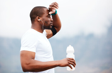 Canvas Print - Black man, runner and tired with water and earphones, music or podcast, relax and fitness outdoor. Hydration, health and plastic bottle, listen to radio on run with exercise, mockup space and train