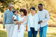 © Anela/peopleimages.com - Nature, walking and family generations in a park for bonding, having fun and talking together. Happy, smile and child with her parents and grandparents in an outdoor green garden on a weekend trip.