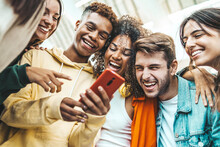 Multiracial Young People Using Smart Mobile Phone Device Outdoors - Happy Teenagers Watching Funny Reel On Smartphone - Technology Life Style Concept
