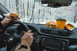 © phpetrunina14 - man driving stopped to eat fast food car behind windshield winter landscape