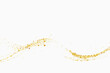 Scattered golden particles on a white background. Festive background or design element. Gold glitters wave