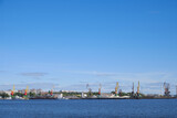 Fototapeta Miasto - Landscape with a view of the river and the port, cranes