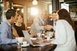 © Marko Geber - Diverse group of business coworkers having a meeting in a cafe or bar