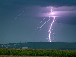 Wall Mural - branched lightning hits earth behind a hill