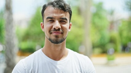 Wall Mural - Young hispanic man standing with serious expression at park