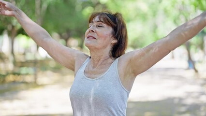 Wall Mural - Middle age woman wearing sportswear breathing at park