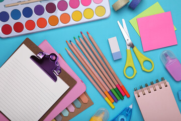 Wall Mural - Flat lay composition with clipboard and other school stationery on light blue background. Back to school