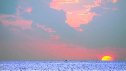Wall Mural - sunset on the sea with fishing boat and red orange yellow cloud background time lapse