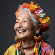 Professional studio head shot of a joyful 70-year-old Southeast Asian woman, eyes looking down.