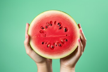 Wall Mural - Female hands with slices of ripe watermelon on green background