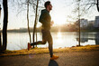 © baranq - Man jogging in park during autumn or winter sunset