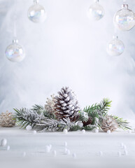Wall Mural - christmas still life with snowy pine cones, baubles and fir branches on light background. winter or 