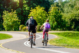 Fototapeta  - Cyclists ride on the bike path in the city Park
