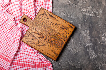 Wall Mural - Cutting board over towel on wooden kitchen table. Cutting board and kitchen towel on black textured background. Menu food card or recipes background concept.MOCKUP. Design. Place for text, copy space.