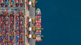 Fototapeta Zachód słońca - Industrial import-export port prepare to load containers. Aerial top view container ship in export and import global business and logistic. Global transportation and logistic business.