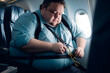 Problem of Fat obese Man passenger fastening Seat belt on airplane