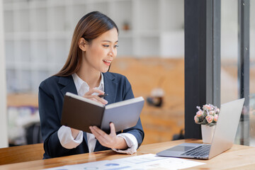 Wall Mural - Asian Business woman using calculator and laptop for doing math finance on an office desk, tax, report, accounting, statistics, and analytical research concept
