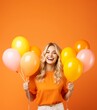 Beauty joyful teenage girl with orange yellow air balloons smiling on orange background with copy space, Thanksgiving celebration concept backgrounds.