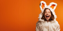 Happy Laughing Young Woman IWearing Bunny Costume For Halloween And/or Easter On An Orange Background With Space For Copy