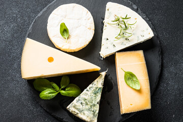 Sticker - Cheese assortment on slate board at black background. Cheese set assortment. Top view with copy space.