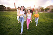 © CarlosBarquero - Multiracial youth excited group having fun and running around green meadow. Outdoor recreational activities with friends and fun on sunny day in city park. Healthy and positive relationships.