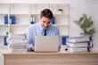 © Elnur - Young male employee and too much work in the office