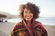 © Anne Schaum - Medium shot portrait photography of a Peruvian woman in her 50s wearing a cozy sweater against a beach background