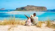 © Fokke Baarssen - Crete Greece, Balos lagoon Crete island, Greece. Tourists relax at the crystal clear ocean of Balos Beach. a couple of men and a woman visit the beach during a vacation in Greece on a sunny day