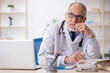 © Elnur - Old male doctor working in the clinic